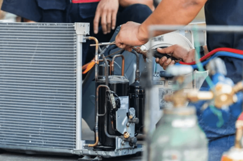 Close-up on hands working on electrical wires on an HVAC unit